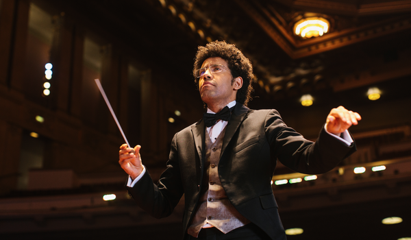 cropped photo of Rafael Payare, the music director for San Diego Symphony, conducting a concert